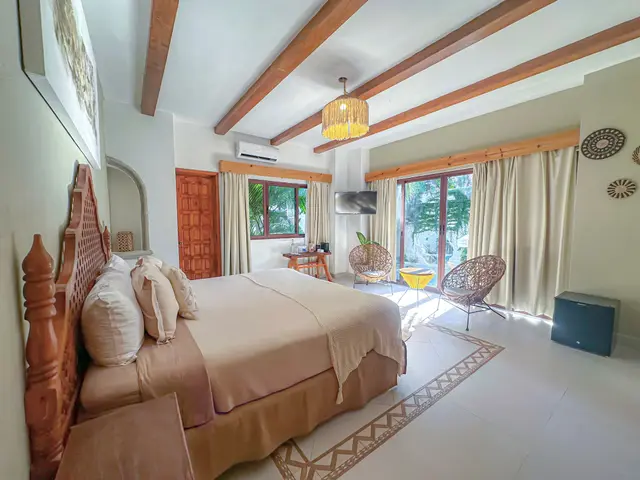 Habitación deluxe con cabecera tallada y vigas de madera