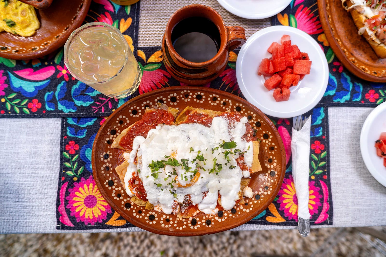 Chilaquiles servidos en plato de barro en Los Compadres