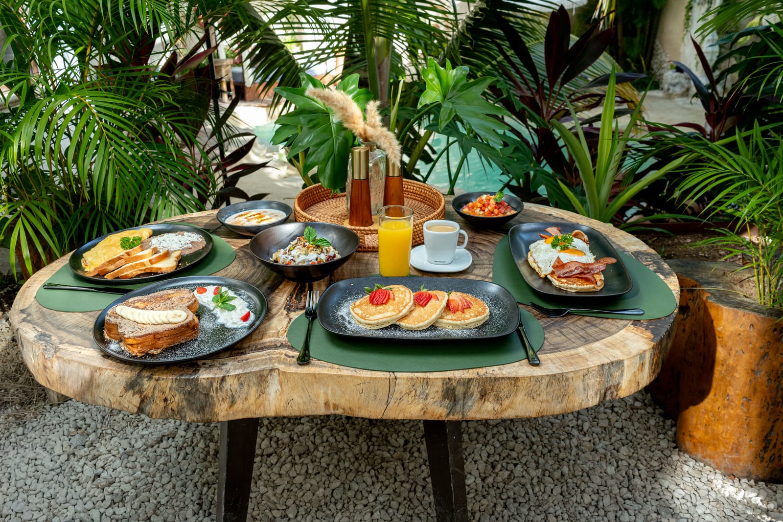 Breakfast table at MERO 18 in the garden: hotcakes, French toast and juices