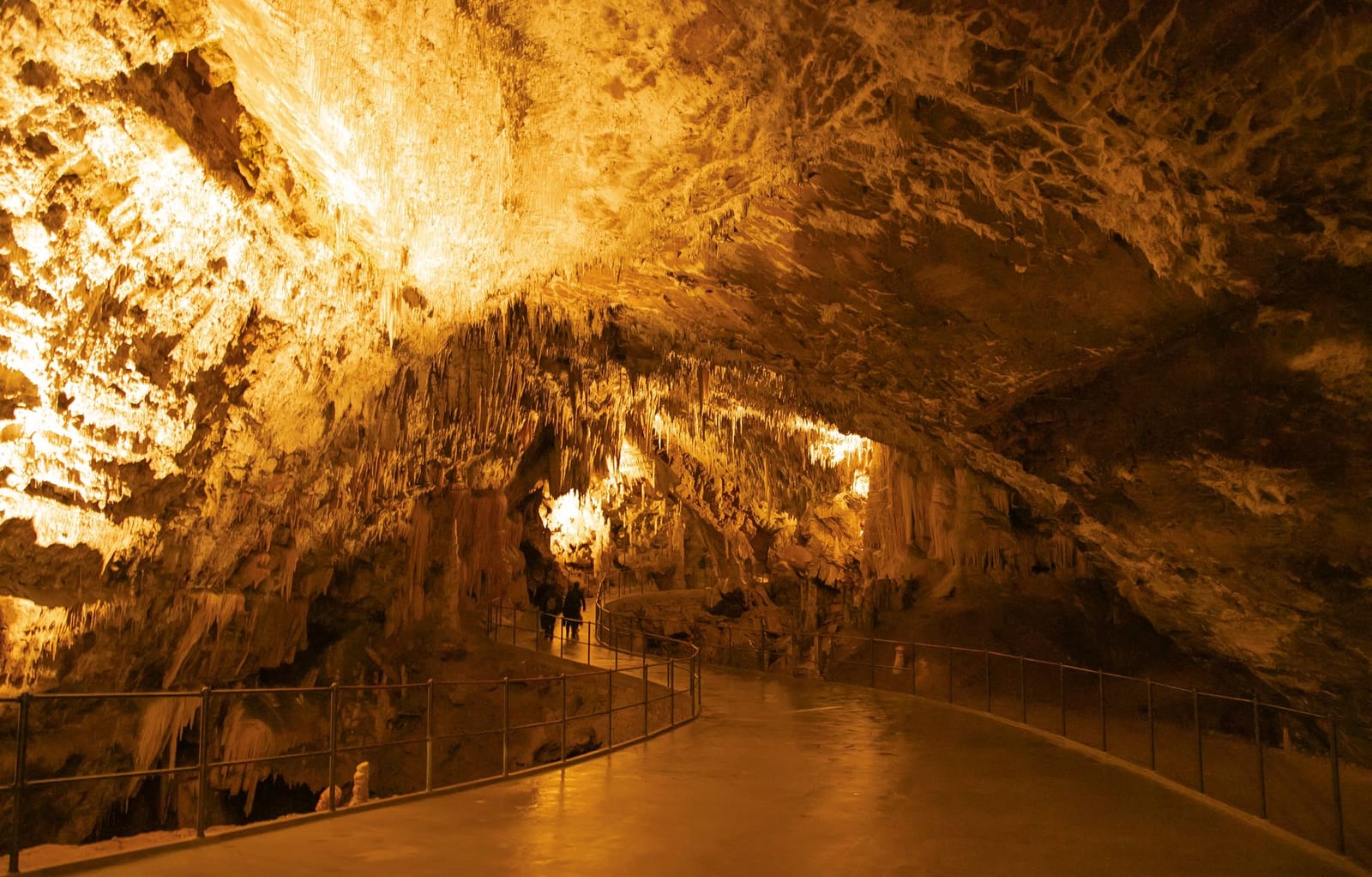 Caverna iluminada con estalactitas y agua en Río Secreto