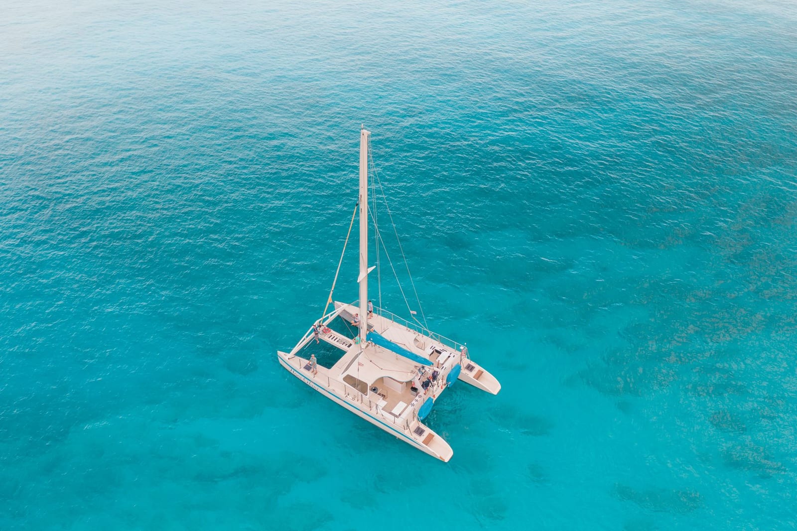 Catamarán sobre agua turquesa del Caribe, experiencias desde Mezcal Hotel Boutique